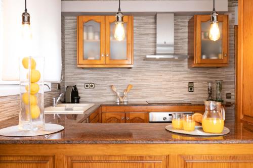a kitchen with wooden cabinets and oranges on a counter at Villa Bo in Deltebre