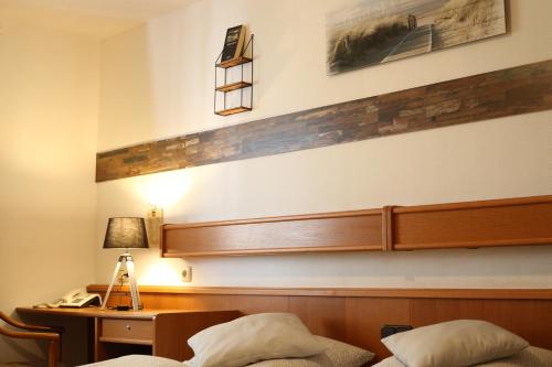 a bedroom with a bed and a desk with a lamp at Hotel Restaurant Bürgerstube in Ulmen