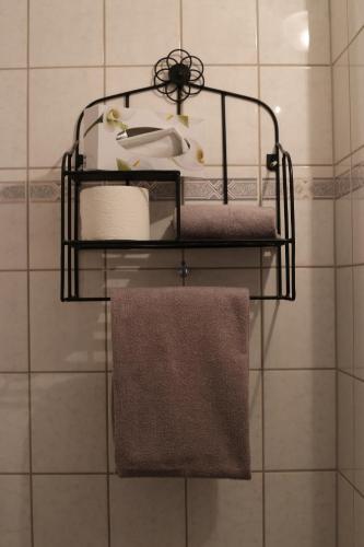 baño con 3 estanterías con toallas y lavamanos en Hotel Restaurant Bürgerstube, en Ulmen