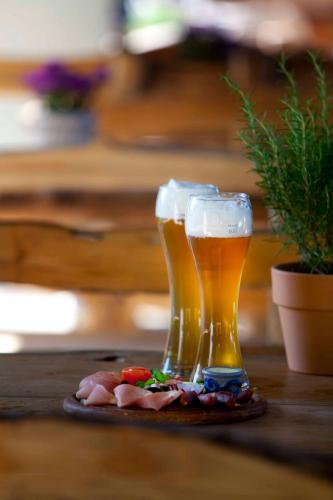 two glasses of beer and food on a table at Hotel Hüttenmühle Hillscheid in Hillscheid