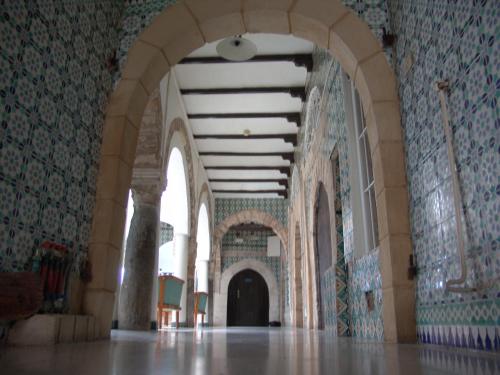 a hallway of a building with a tile wall at Hôtel Medina in Sousse