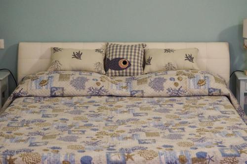 uma cama com um cobertor e almofadas em Tra Monti e Mare em La Spezia