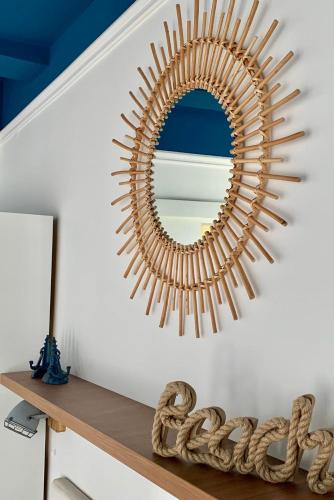 a mirror on a wall above a wooden shelf at Villa Tamaris on the beach in Podstrana