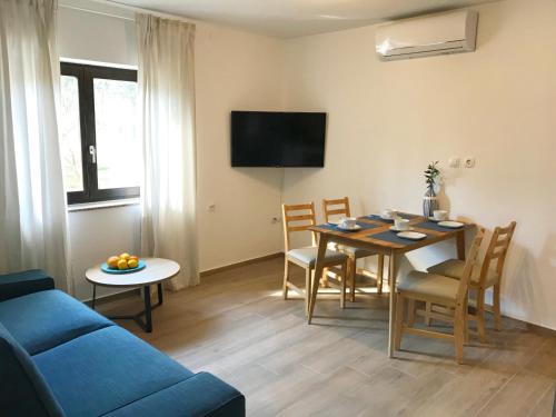 ein Wohnzimmer mit einem blauen Sofa und einem Tisch in der Unterkunft Apartmani Lavanda in Vrsi