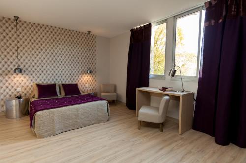 een slaapkamer met een bed, een bureau en een raam bij La Quietat in Toulouse