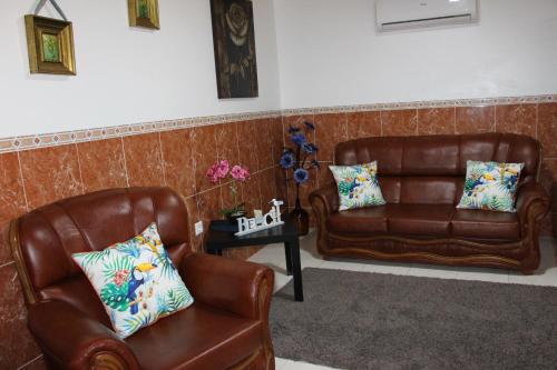 two brown leather chairs and a table with pillows at Casa do Facho in Vila Chã