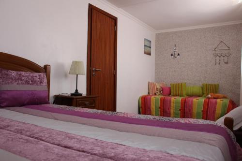 a bedroom with a large bed and a couch at Casa do Facho in Vila Chã