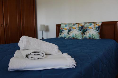 a pile of towels sitting on top of a bed at Casa do Facho in Vila Chã