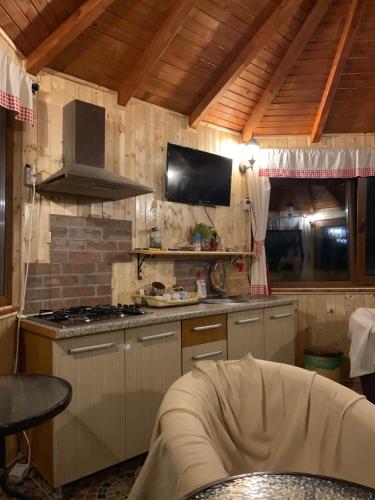 a kitchen with a stove and a tv on the wall at Casa Galbena in Slănic