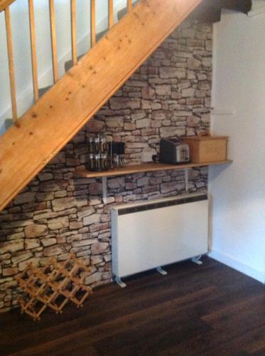 a staircase with a stone wall with a shelf on it at Arosfa in Bala