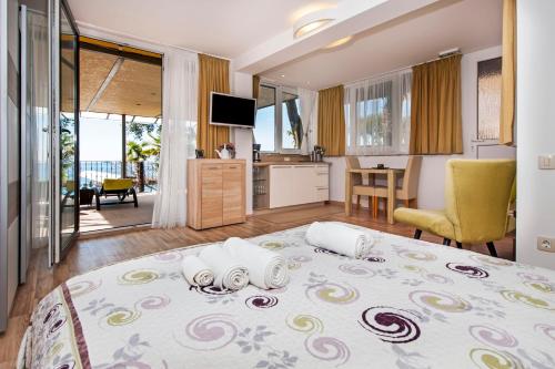 a bedroom with a large bed and a kitchen with a view at Apartments Figarola in Rovinj