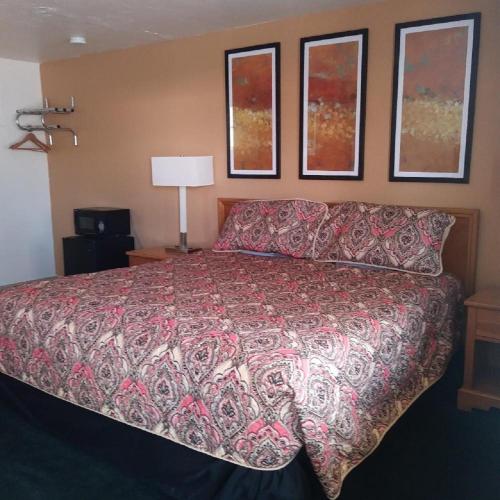 a bedroom with a bed with a red comforter at Budget Inn Durango in Durango