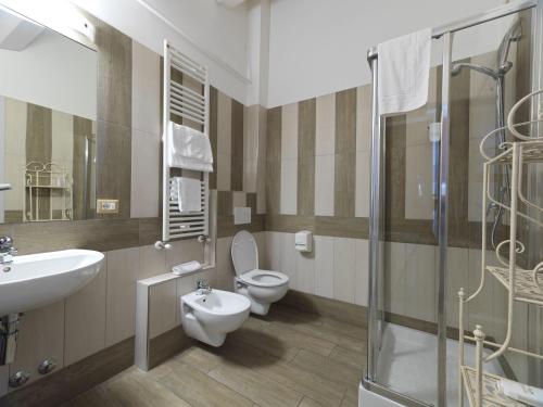 コリナルドにあるHotel Ristorante Cantina Langelinaのバスルーム(トイレ2つ、シンク、シャワー付)