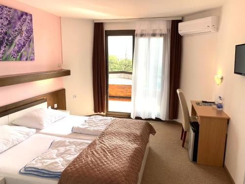 una camera d'albergo con letto, scrivania e finestra di Hotel Ruža a Novi Vinodolski