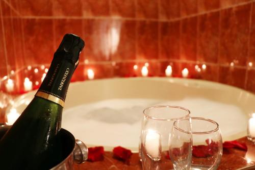 - Botella de champán y 2 copas en una mesa con bañera en Hotel Bohemia, en Lima
