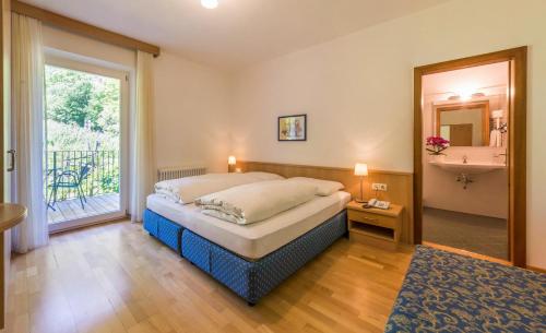 1 dormitorio con 1 cama y baño con ventana en Pension Gruenwald, en Andrian