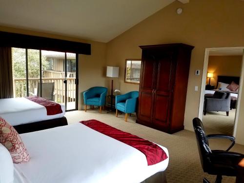 a hotel room with two beds and a balcony at Adobe Inn in Carmel