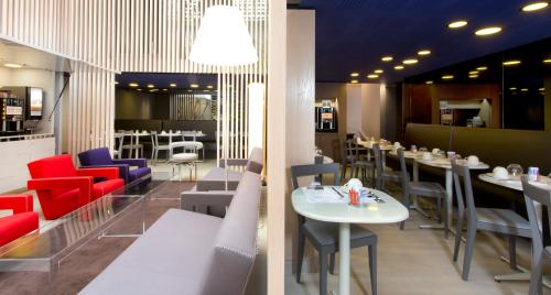 パリにあるリベルタル ガル ドゥ レスト フランセの赤と青の椅子とテーブルが備わるレストラン
