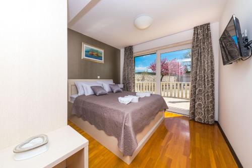 ein Schlafzimmer mit einem Bett und einem großen Fenster in der Unterkunft Villa AnBer in KoruÅ¡ce