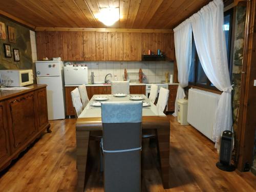 a kitchen with a table with chairs and a counter top at Loutra Mountain Nature in Aridaia