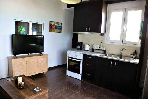 a kitchen with a sink and a stove top oven at Havana 1 Sea and Pool Apartment in Amoudara Herakliou