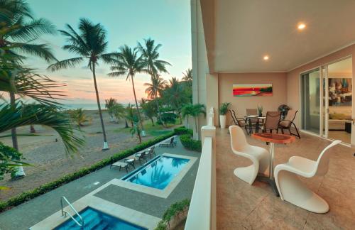 a house with a swimming pool and a view of the ocean at The Palms Ocean Club Resort in Jacó