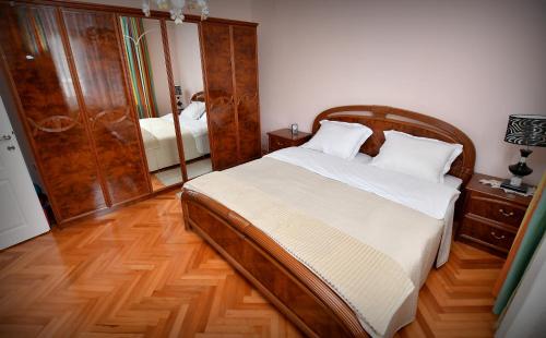 - une chambre avec un grand lit et un miroir dans l'établissement Villa Nena, à Kladovo