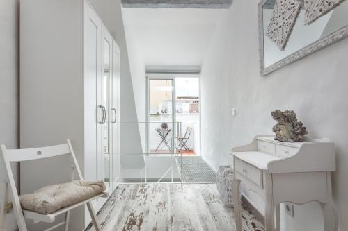 a white room with a desk and a chair at CASA DO PESCADOR by Ammonite&Co in Olhão