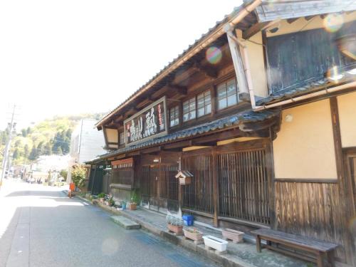 a building with a bench in front of a street at Nouka Minsyuku Hyousa in Minamiechizen