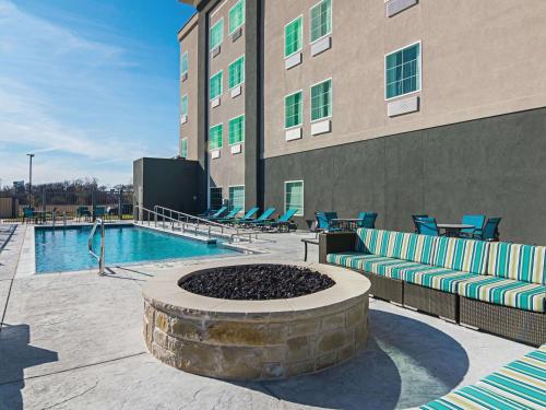 a pool in front of a building with lounge chairs at La Quinta by Wyndham Dallas - Wylie in Wylie