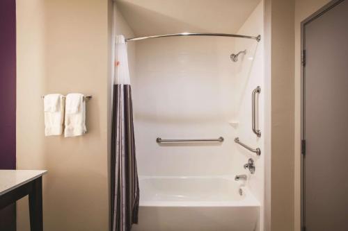 a bathroom with a shower and a bath tub at La Quinta by Wyndham Dallas Northeast-Arboretum in Garland