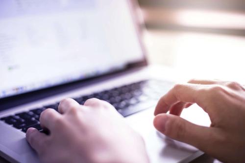 a person is typing on a laptop computer at La Quinta by Wyndham South Jordan in South Jordan