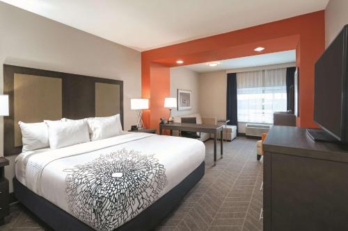 a hotel room with a bed and a desk at La Quinta by Wyndham Opelika Auburn in Opelika