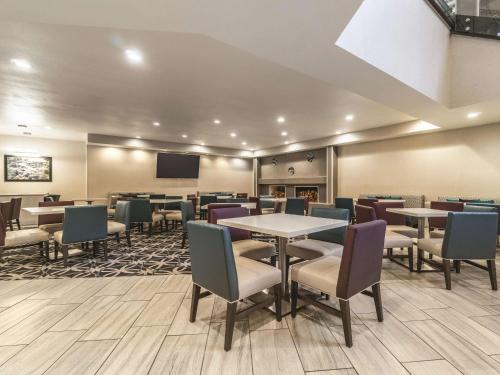 a dining room with tables and chairs and a tv at La Quinta by Wyndham Glenwood Springs in Glenwood Springs