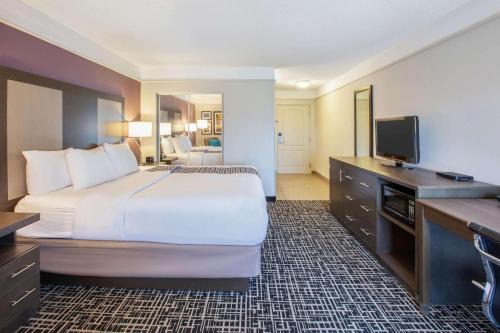 a hotel room with a large bed and a flat screen tv at La Quinta by Wyndham Cincinnati Airport Florence in Florence
