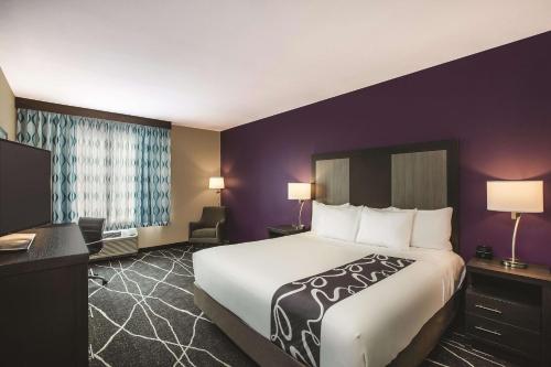 a hotel room with a large bed and a desk at La Quinta by Wyndham Dallas Northeast-Arboretum in Garland