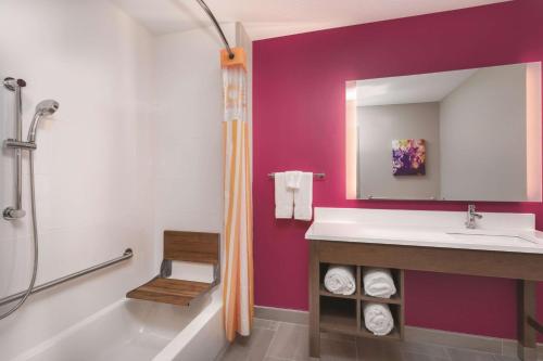 a bathroom with a sink and a tub and a mirror at La Quinta by Wyndham South Jordan in South Jordan