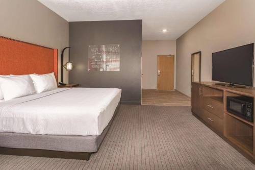 a hotel room with a bed and a flat screen tv at La Quinta by Wyndham South Jordan in South Jordan