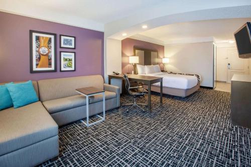 a hotel room with a bed and a couch at La Quinta by Wyndham Cincinnati Airport Florence in Florence