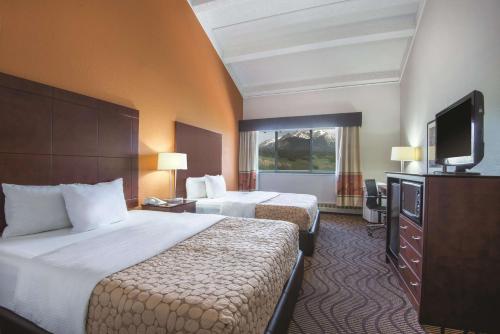 a hotel room with two beds and a flat screen tv at La Quinta by Wyndham Silverthorne - Summit Co in Silverthorne