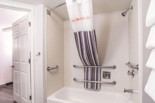 a bathroom with a tub and a shower curtain at La Quinta by Wyndham Flagstaff in Flagstaff