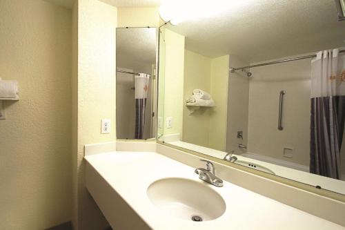 a bathroom with a sink and a large mirror at La Quinta by Wyndham Coral Springs University Dr in Coral Springs