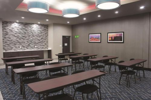 a dining room with tables and chairs and a stone wall at La Quinta by Wyndham Kanab in Kanab