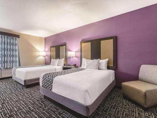 two beds in a hotel room with a purple wall at La Quinta by Wyndham Glenwood Springs in Glenwood Springs