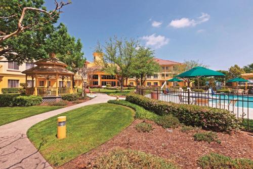 a park with a pool and lawn chairs at La Quinta by Wyndham Dallas DFW Airport North in Irving