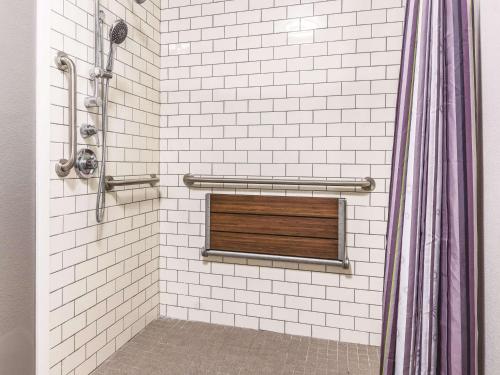 a shower with a window in a white tiled bathroom at La Quinta by Wyndham Alexandria Airport in Alexandria