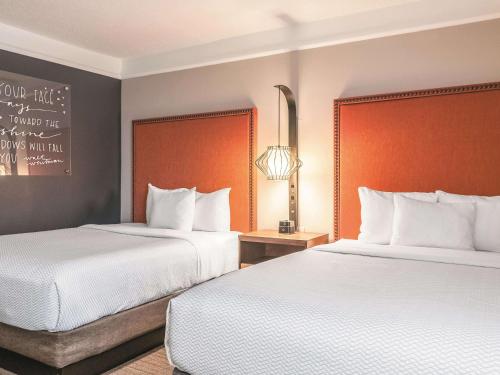 a hotel room with two beds and a sign on the wall at La Quinta by Wyndham New Orleans Downtown in New Orleans