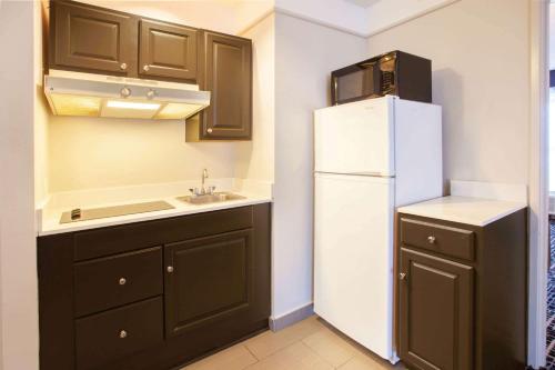 a kitchen with a white refrigerator and a sink at La Quinta by Wyndham Cincinnati Airport Florence in Florence