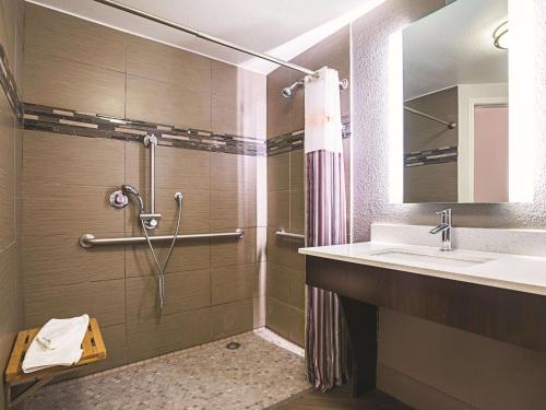 ein Bad mit einer Dusche und einem Waschbecken in der Unterkunft La Quinta by Wyndham Dallas Plano West in Plano