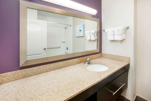 a bathroom with a sink and a large mirror at La Quinta by Wyndham Cincinnati Airport Florence in Florence